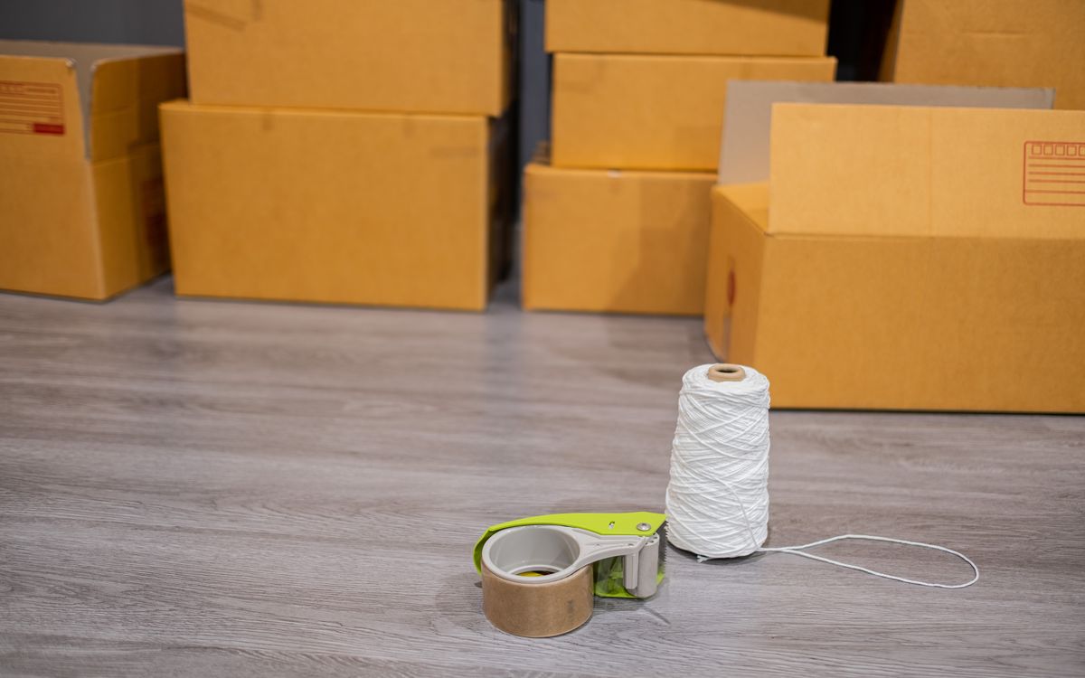 Workbench with neatly packed bulb orders in boxes alongside shipping labels and a roll of packing tape