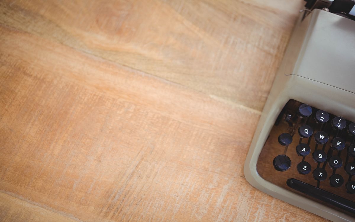 Close-up of a payment terminal beside a handwritten invoice on a wooden counter
